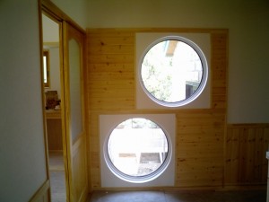 丸窓の向こうは浴室の坪庭。玄関ホール。